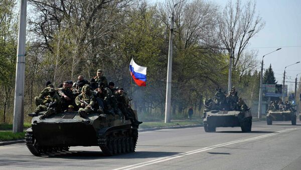 Люди, одетые в военную форму на боевой технике с флагом России около Краматорска