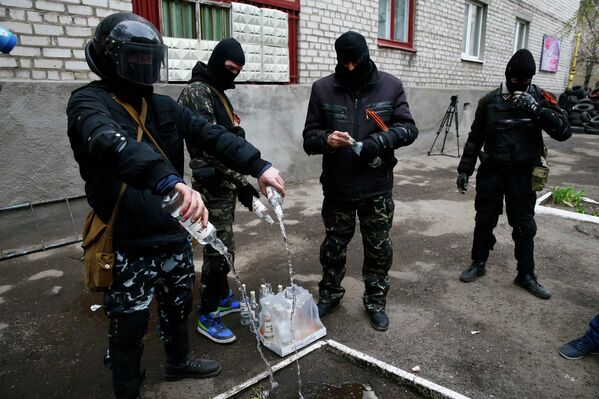 Люди в масках используют пустые бутылки водки для бензиновых бомб в Славянске