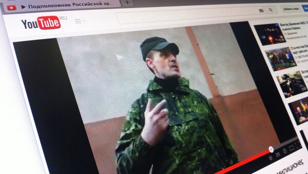 Кадр из видео, в котором мужчина в камуфляже представляется подполковником российской армии и отдает приказания сотрудникам милиции Горловки