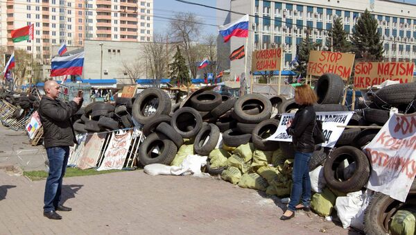 Люди фотографируются у баррикад возле здания СБУ в Луганске 17 апреля 2014