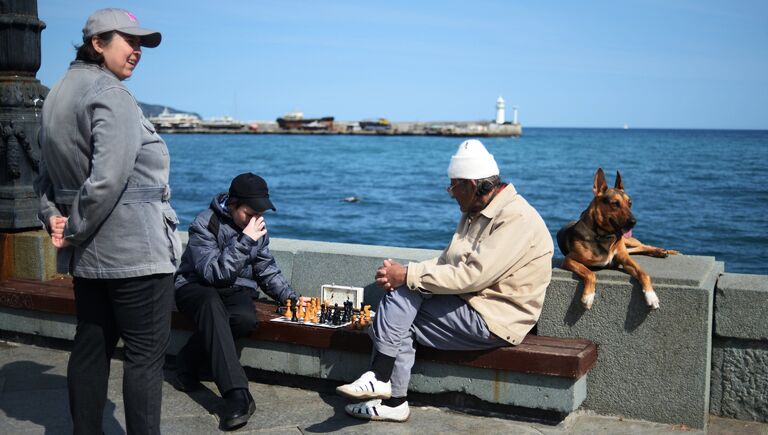 Отдыхающие играют в шахматы на набережной в Ялте