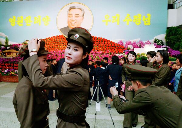 Северокорейские женщины-солдаты готовятся к общему снимку на праздновании дня рождения основателя Северной Кореи Ким Ир Сена