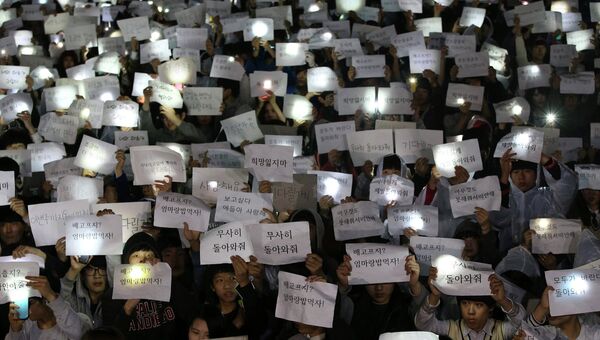 Студенты держат таблички с пожеланиями спасения пассажирам затонувшего у берегов Южной Кореи парома Севол
