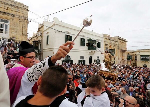 Священник благословляет верующих во время пасхальной процессии в Коспикуа, Мальта