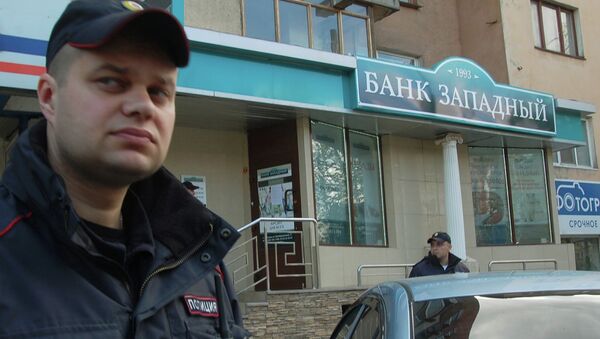 Сотрудники полиции у входа в отделение банка Западный в Белгороде