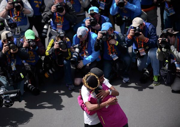 Победитель бостонского марафона Меб Кефлезигхи обнимает победительницу Риту Джепту