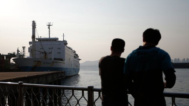 Люди смотрят на паром компании Chonghaejin Marine Co., которой принадлежал затонувший у берегов Южной Кореи паром Севол