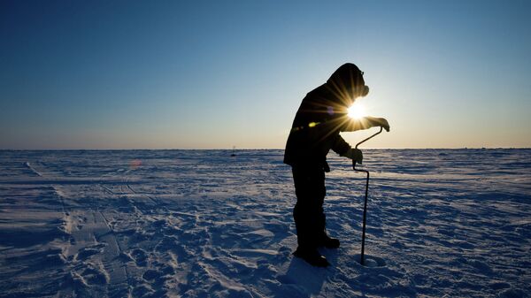 Российский ученый бурит лед для взятия пробы на Северном Полюсе. Архивное фото