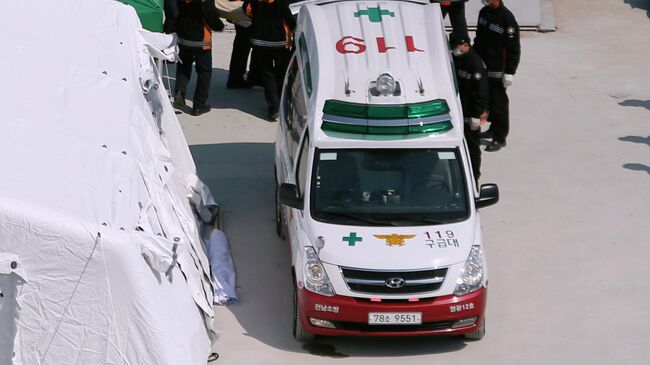 Южнокорейские спасатели возле автомобиля скорой помощи