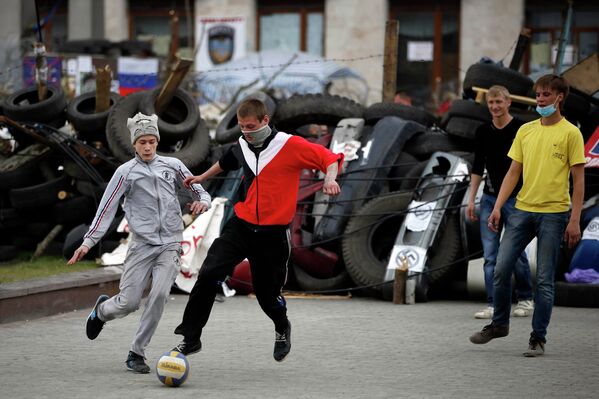 Подростки играют в футбол возле областной администрации в Донецке