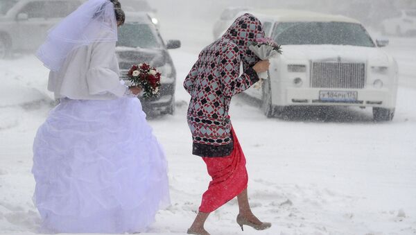 МНевеста идет по улице во время сильного снегопада в Челябинске