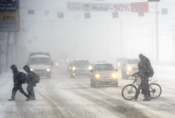 Пешеходы переходят дорогу во время сильного снегопада в Челябинске
