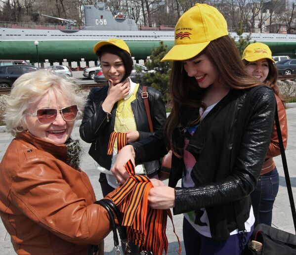 Волонтеры раздают георгиевские ленточки на Корабельной набережной в городе Владивостоке
