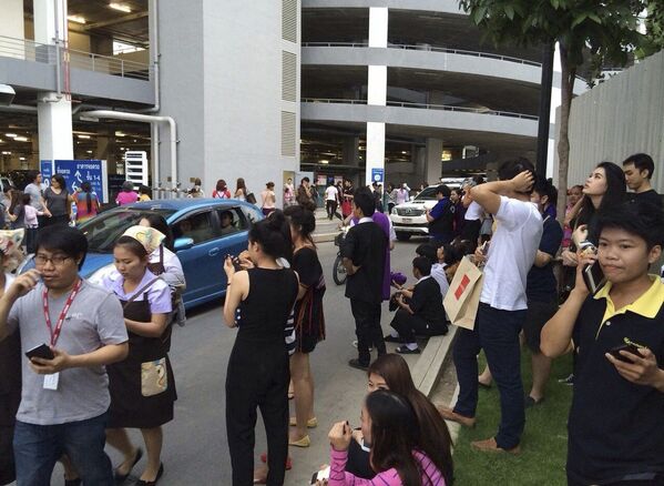 Эвакуированные из здания люди во время землетрясения в Таиланде