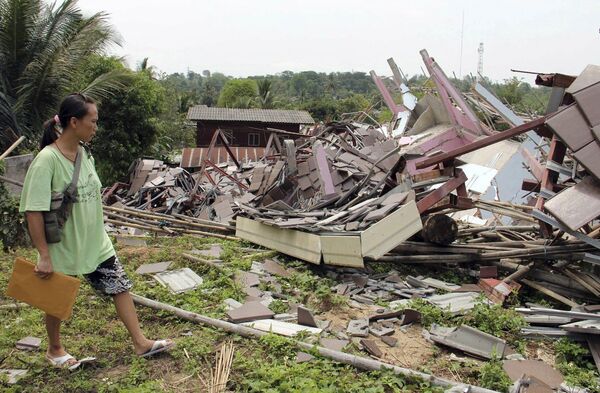 Женщина рядом со своим домом, разрушенным в результате землетрясения в Таиланде