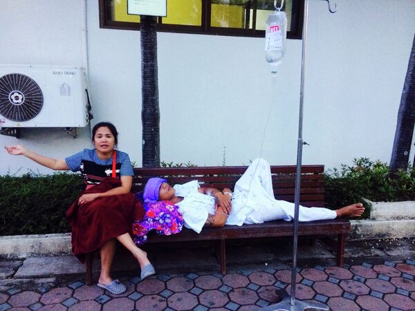 Женщина рядом с эвакуированным из больницы пациентом во время землетрясения в Таиланде