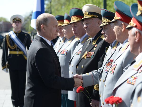 Президент России Владимир с ветеранами во время церемонии возложения цветов к Вечному огню у Могилы Неизвестного Солдата