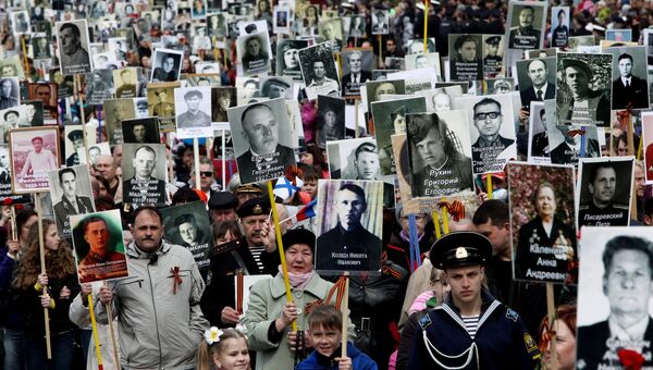 Горожане несут портреты участников Великой Отечественной войны в колонне Бессмертного полка на праздновании Дня Победы