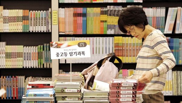 Женщина выбирает учебники в книжном магазине в Южной Корее. Архивное фото