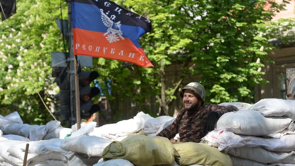 Активист сил самообороны сторонников федерализации Украины на баррикаде под флагом ДНР