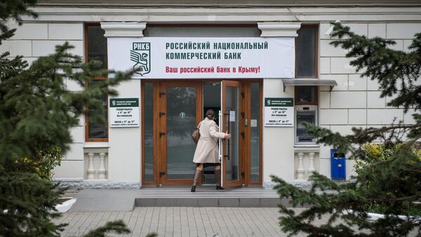 Женщина входит в здание Российского национального коммерческого банка в городе Севастополе, архивное фото
