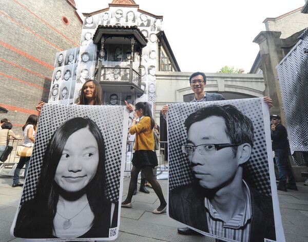 Посетители держат свои портреты на выставке французского художника JR в Шанхае