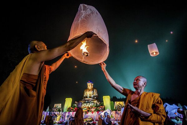 Буддистские монахи запускают бумажный фонарик во время праздника Весак
