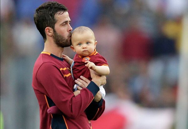 Игрок AS Roma Миралем Пьянич целует своего сына в конце футбольного матча