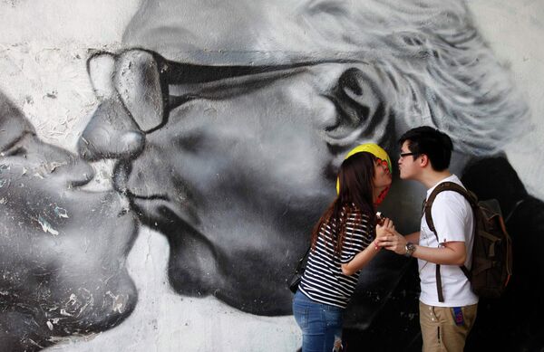 Парочка целуется на фоне граффити в Сеуле, Южная Корея