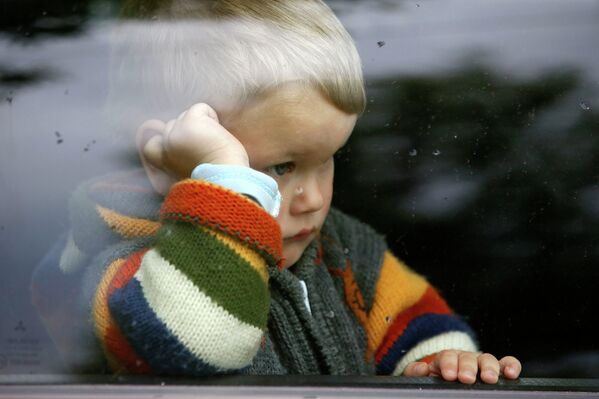 Мальчик смотрит в окно автобуса в Мариуполе