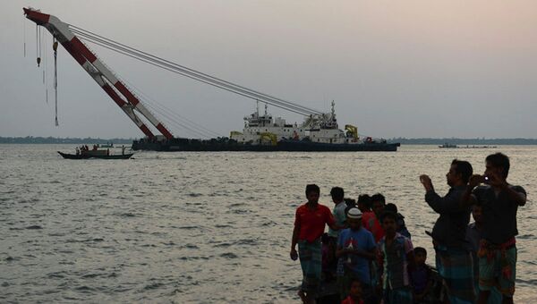 Бангладешские спасатели пытаются вытащить на берег затонувший паром