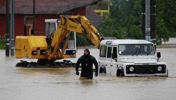 Спасатель идет по затопленной улице города Лазаревац, Сербия