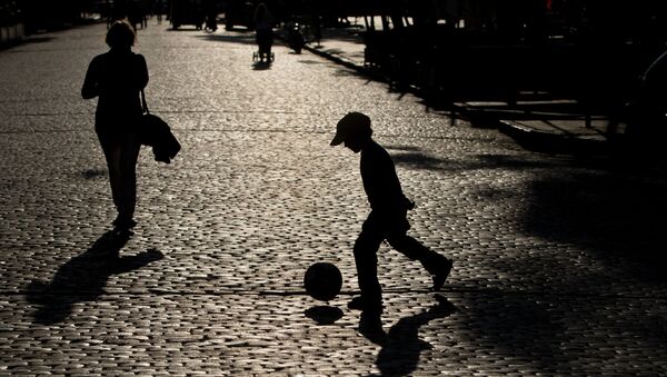 Ребенок играет в мяч на улице в Одессе 11 мая 2014
