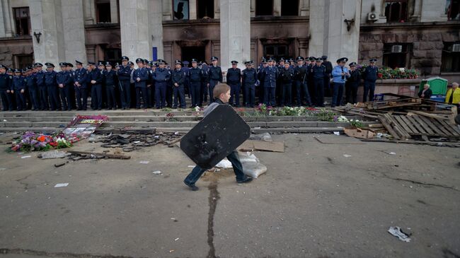Ребенок гуляет возле сгоревшего здания Дома профсоюзов в Одессе