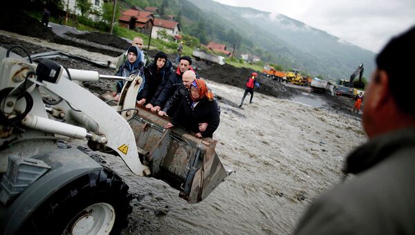Люди переносятся фронтальным погрузчиком, во время эвакуации недалеко от города Жепче