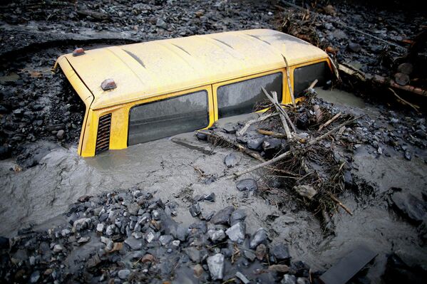 Транспортное средство в грязи на улице, которая пострадала от наводнения недалеко от города Жепче