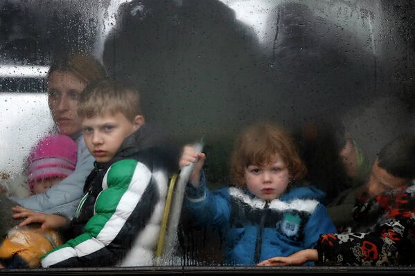Дети сидят в автобусе после эвакуации из зоны затопления города Оберновац