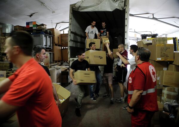Волонтеры разгружают грузовик с гуманитарной помощью, собранных македонскими гражданами на складе Красного Креста в Скопье