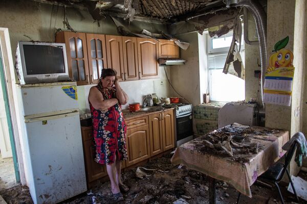 Женщина в своем доме, разрушенном в результате ночного артобстрела со стороны украинских военных на окраине Славянска