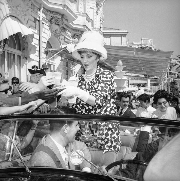 Итальянская актриса Джина Лоллобриджида дает автографы многочисленным поклонникам перед отелем на набережной Круазет, Каннский кинофестиваль, 11 мая 1961 года