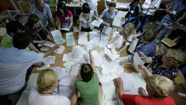 Члены избирательной комиссии во время подсчета голосов на одном из избирательных участков в Киеве