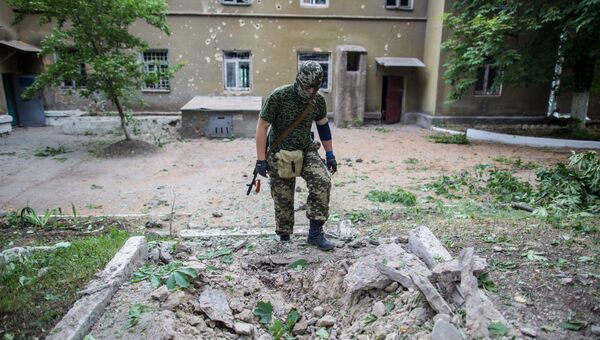 Боец народного ополчения у воронки от снаряда во дворе больницы в поселке Семеновка