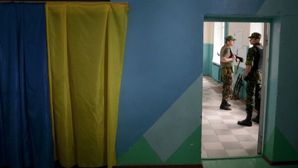 Украинские солдаты стоят возле стендов во время голосования на президентских выборах на избирательном участке под Донецком 25 мая 2014