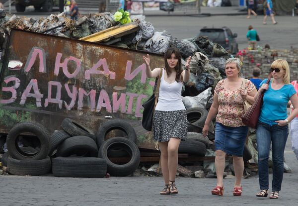 Люди идут вдоль баррикад на площади Независимости в Киеве