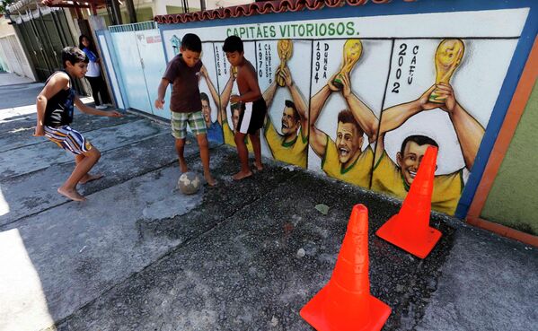 Мальчики играют с мячом возле граффити в Рио-де-Жанейро, Бразилия