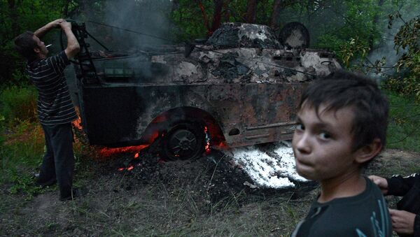 Местные жители у горящей разведывательно-дозорной машины украинских силовиков в Луганской области