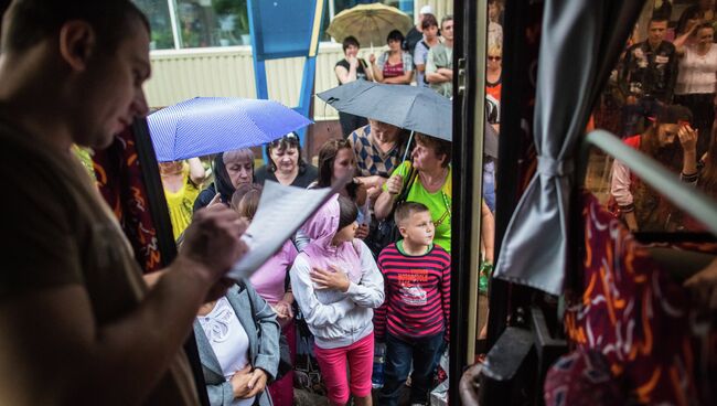 Родители с детьми во время посадки в автобусы. Архивное фото