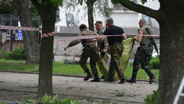 Народные ополченцы несут раненого в результате авианалета ВВС Украины на здание обладминистрации в Луганске