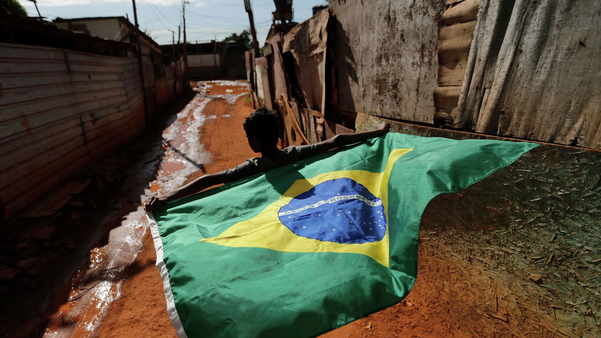Мальчик с бразильским национальным флагом в трущобах города Бразилиа - РИА Новости, 1920, 22.01.2022