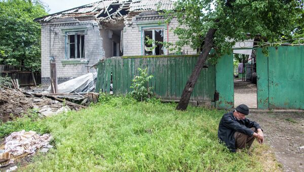 Пожилой мужчина возле своего дома, разрушенного в результате попадания снаряда. Архивное фото